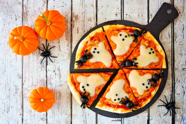 istock Halloween pizza overhead table scene over white wood 1340355211