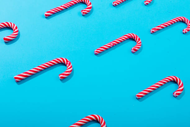istock Composition of rows of multiple candy canes on blue background 1340355459