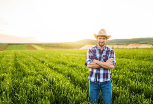 istock Young farmer standing on his agricultural field and looking at camera. 1340358306