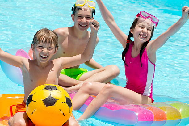 istock Three children playing in a swimming pool 134036451