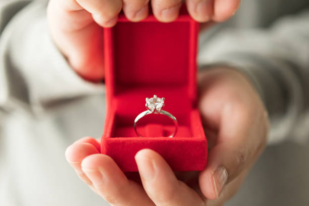 istock hands holding diamond ring in jewelry box 1340367480