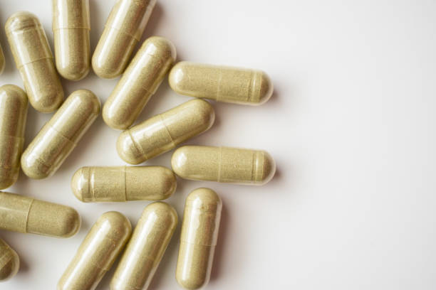 istock Herbal medicine capsules on white background 1340367538