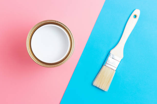 istock Open paint can and paintbrush on blue and pink background top view. 1340376826