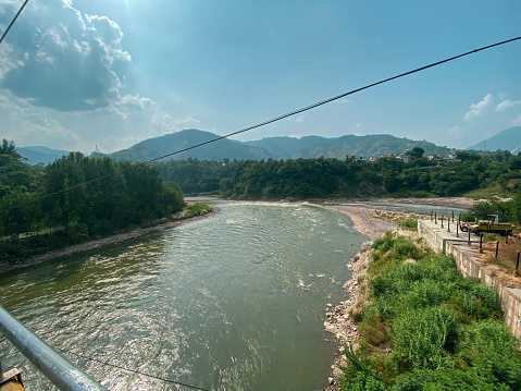 View of flowing river and green mountains from balcony of a house
