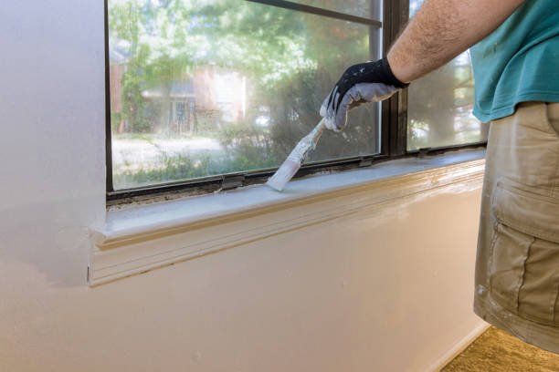 istock Handyman paints a window molding frame at home 1340389722