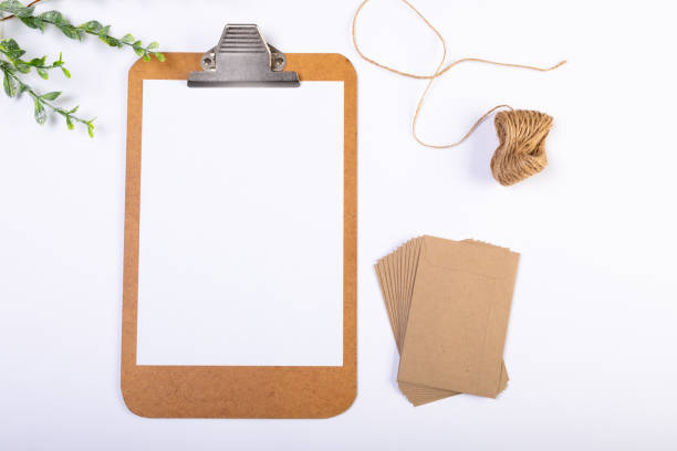 istock Composition of clipboard with copy space and envelopes, string, branches on white background 1340396657