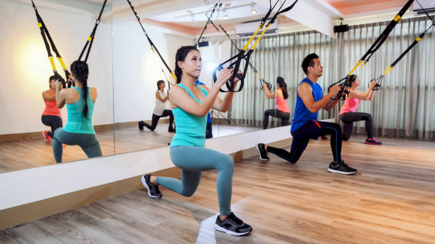 istock people performing TRX suspension training 1340398818