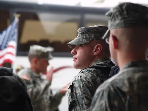 A soldier in formation preparing to board the bus and begin his deployment to War in Iraq.  