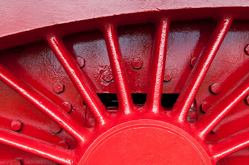 Spokes of a wheel in solid cast steel painted red