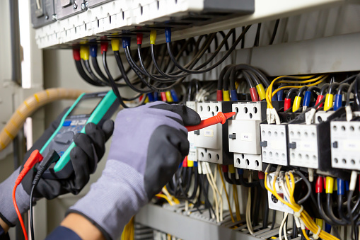 Ingeniero electricista prueba instalaciones eléctricas y cables en el sistema de protección de relés. Ajuste de esquema de automatización y control de equipos eléctricos. photo