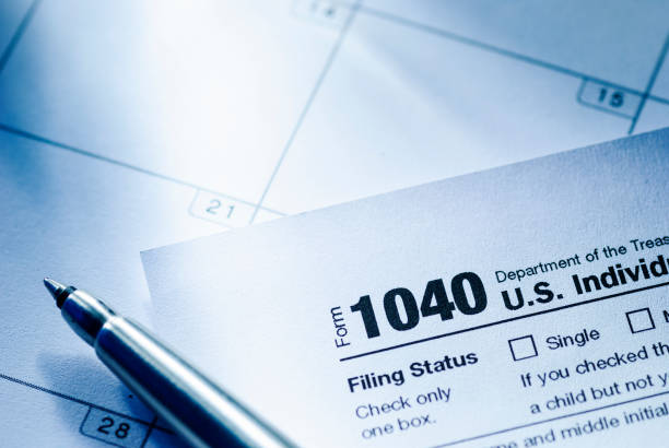 istock Form 1040 with ballpoint pen in a tax concept 1340407177