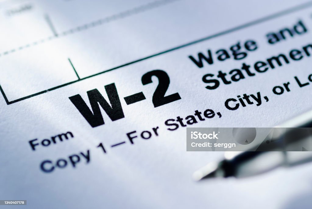 Pen on a Form W-2 Wage and Tax Statement Pen on a Form W-2 Wage and Tax Statement for the US Treasury to be submitted by the employer in close up in a conceptual financial image Tax Form Stock Photo
