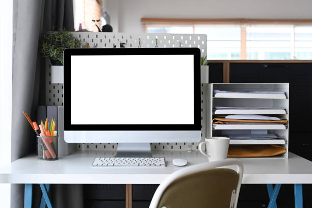 istock Mock up computer with blank screen on white desk in home office. 1340414933