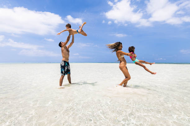 istock Playful parents having fun with their small kids at sea. 1340414996