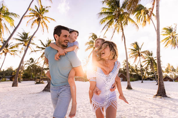 familia despreocupada divirtiéndose mientras se mete en la playa. - family beach vacations travel fotografías e imágenes de stock