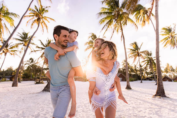 istock Carefree family having fun while piggybacking on the beach. 1340416045