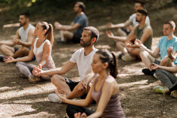 istock Large group of athletes having Yoga class in nature. 1340416192