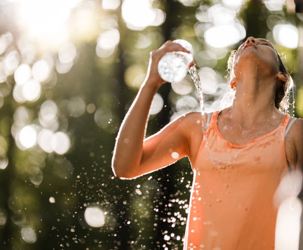 istock Tired female athlete refreshing herself with water in nature. 1340417281