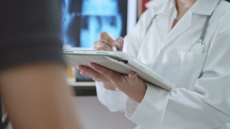 Doctor consulting with patient viewing medical records,Close-up