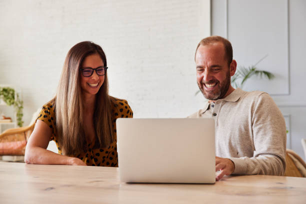 istock Two businesspeople laughing at something on a laptop at work 1340419472