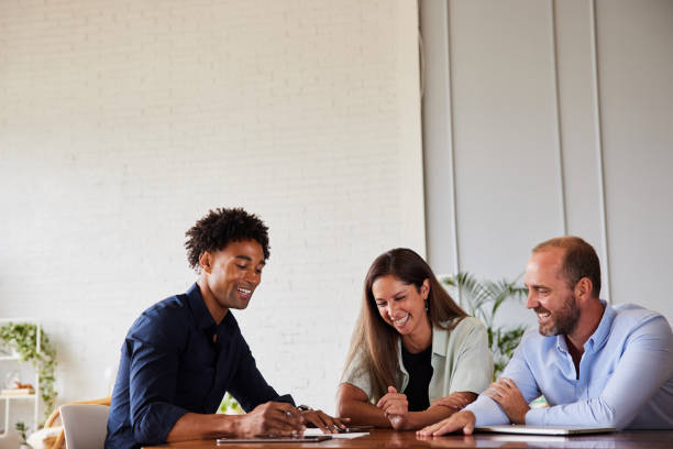istock Diverse businesspeople laughing while working at an office table 1340419684