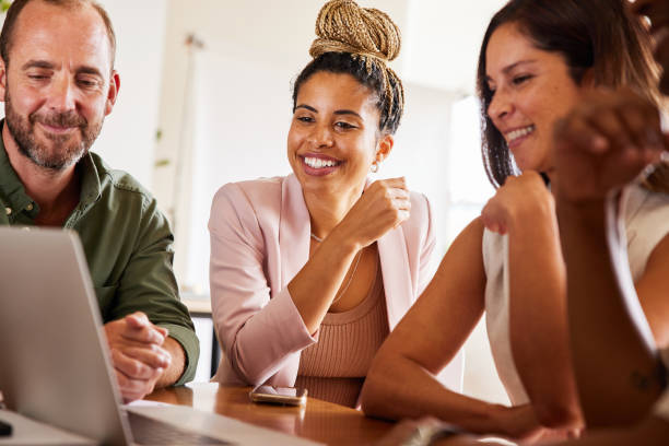 istock Diverse businesspeople laughing during a video call at an office table 1340422004