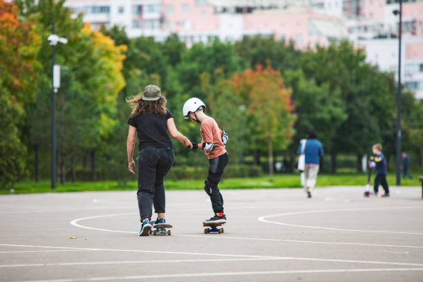 ragazzino skateboard con istruttore - skateboard court foto e immagini stock