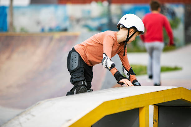 kleiner junge skateboarding im park - skateboard court stock-fotos und bilder