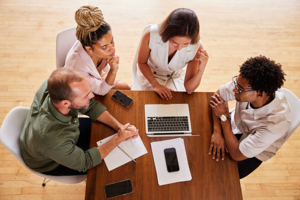 istock Diverse group of businesspeople working together around an office table 1340424517