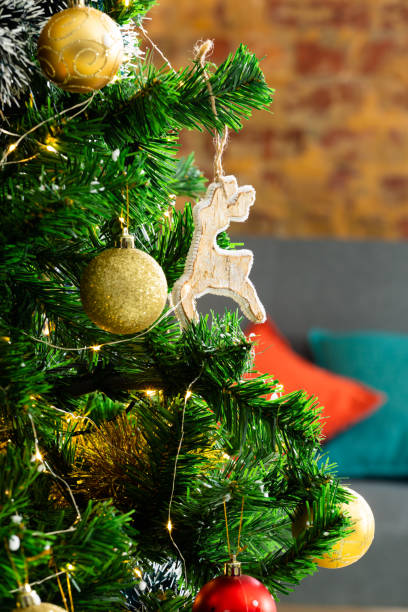 istock Composition of christmas tree with gold baubles and reindeer on blurred background 1340425421