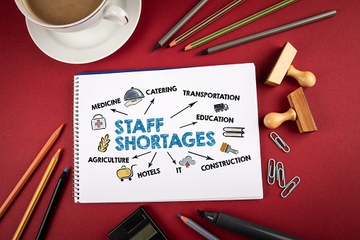 Staff Shortages, business, jobseeker and employer concept. Office supplies on a red table