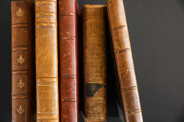 istock Row of old books on dark background 1340425475