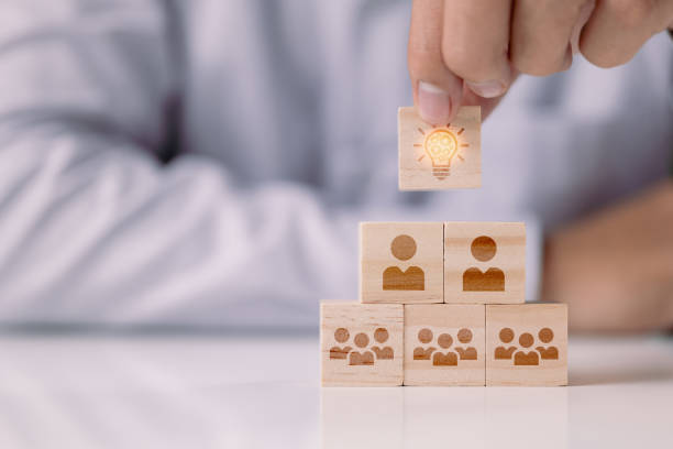 istock brainstorming creative idea and innovation. Hand putting over wooden cube block with light bulb icon on many people teamwork. 1340425780