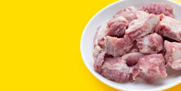 istock Raw pork ribs in white plate on yellow background. 1340425920