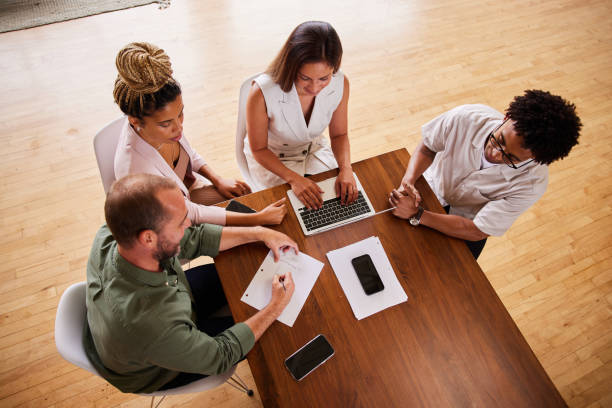istock Diverse group of businesspeople working around an office table 1340427190