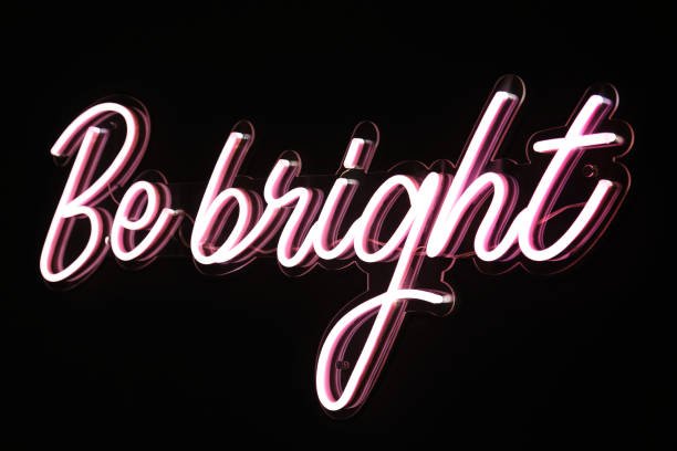 istock Be bright phrase in pink flashing neon letters over black background. 1340433401