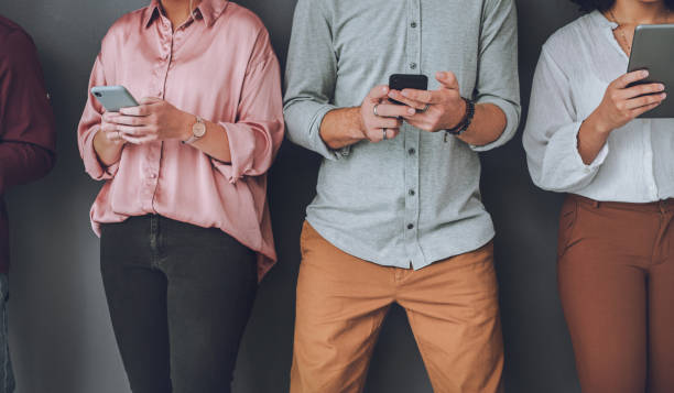 istock Studio shot of an unrecognisable group of people using digital devices against a grey background 1340433830