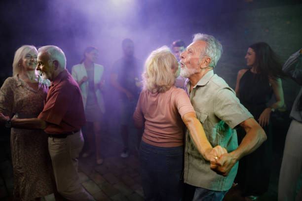 istock Happy mature couples dancing in a disco. 1340435281