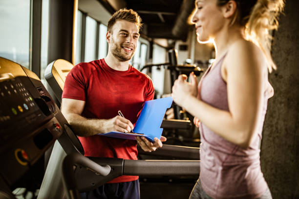 istock Happy coach taking notes while being next to his athlete in a gym. 1340435534