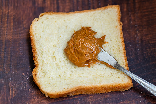 Peanut butter scattered on a slice of bread