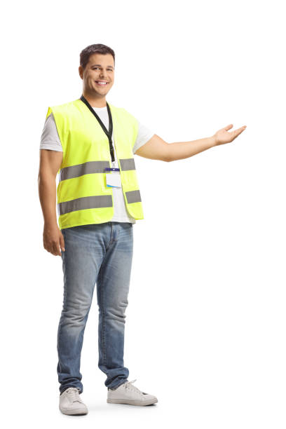 Young man in a safety vest showing with hand