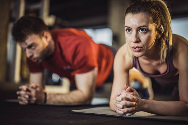istock Athletic couple exercising strength in plank position at gym. 1340436580