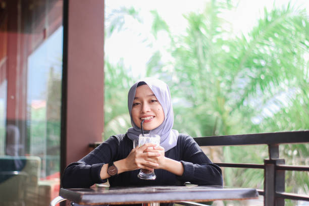 istock Young women sitting drinking at cafe 1340440703
