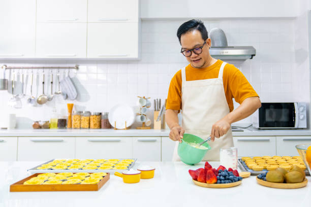 Asian man making whipping cream in the kitchen.