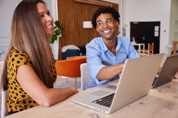 istock Young businesspeople laughing while working together on a laptop in an office 1340441365