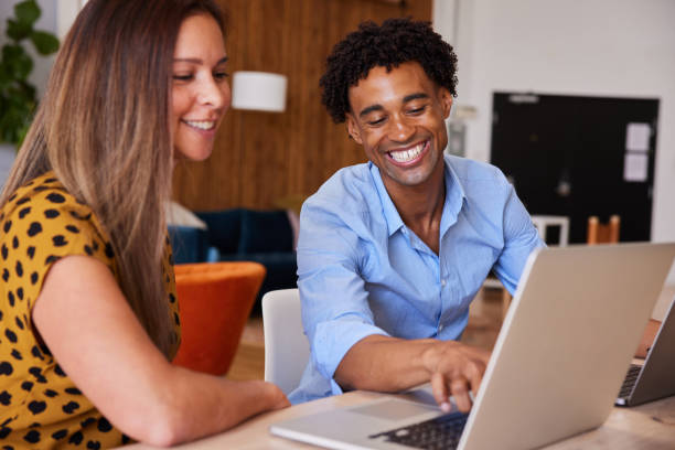 istock Two diverse young businesspeople smiling while working on a laptop 1340443064