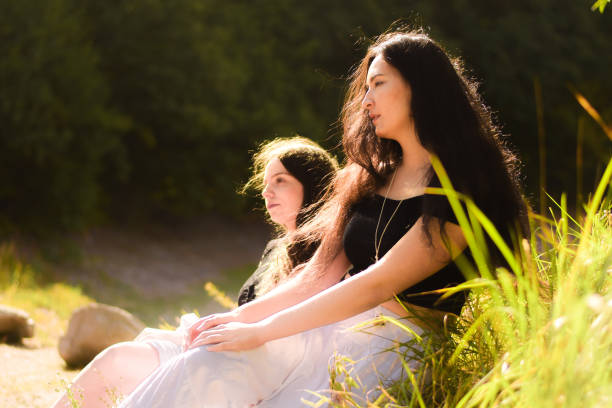istock Two friends sitting and walking by the Lake 1340443107