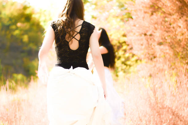 istock Two friends sitting and walking by the Lake 1340443383