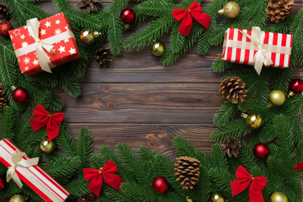 istock Christmas decorations and fir tree branch and gift boxon dark table. Top view frame with copy space 1340443846