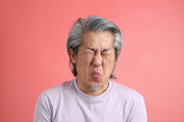 Real Skin Face The senior Asian man portrait with no retouched skin in the pink background. sour face stock pictures, royalty-free photos & images